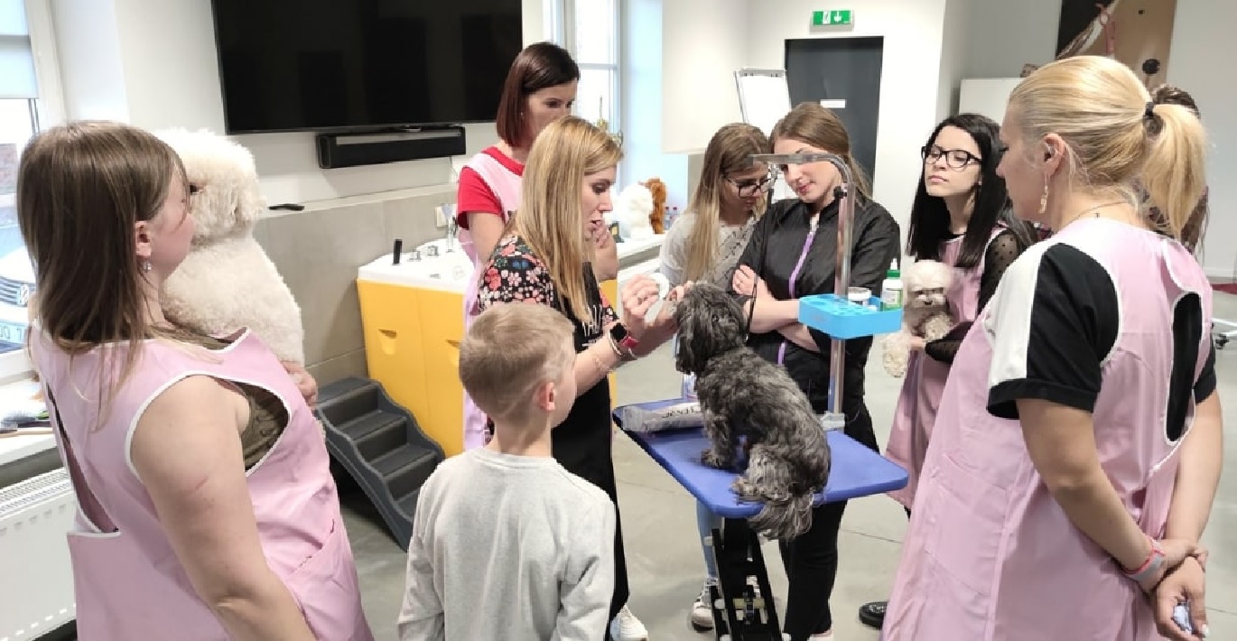 Gyvūnų priežiūros specialistė rodo studentams, kaip tinkamai atlikti šuniui higienos procedūrą